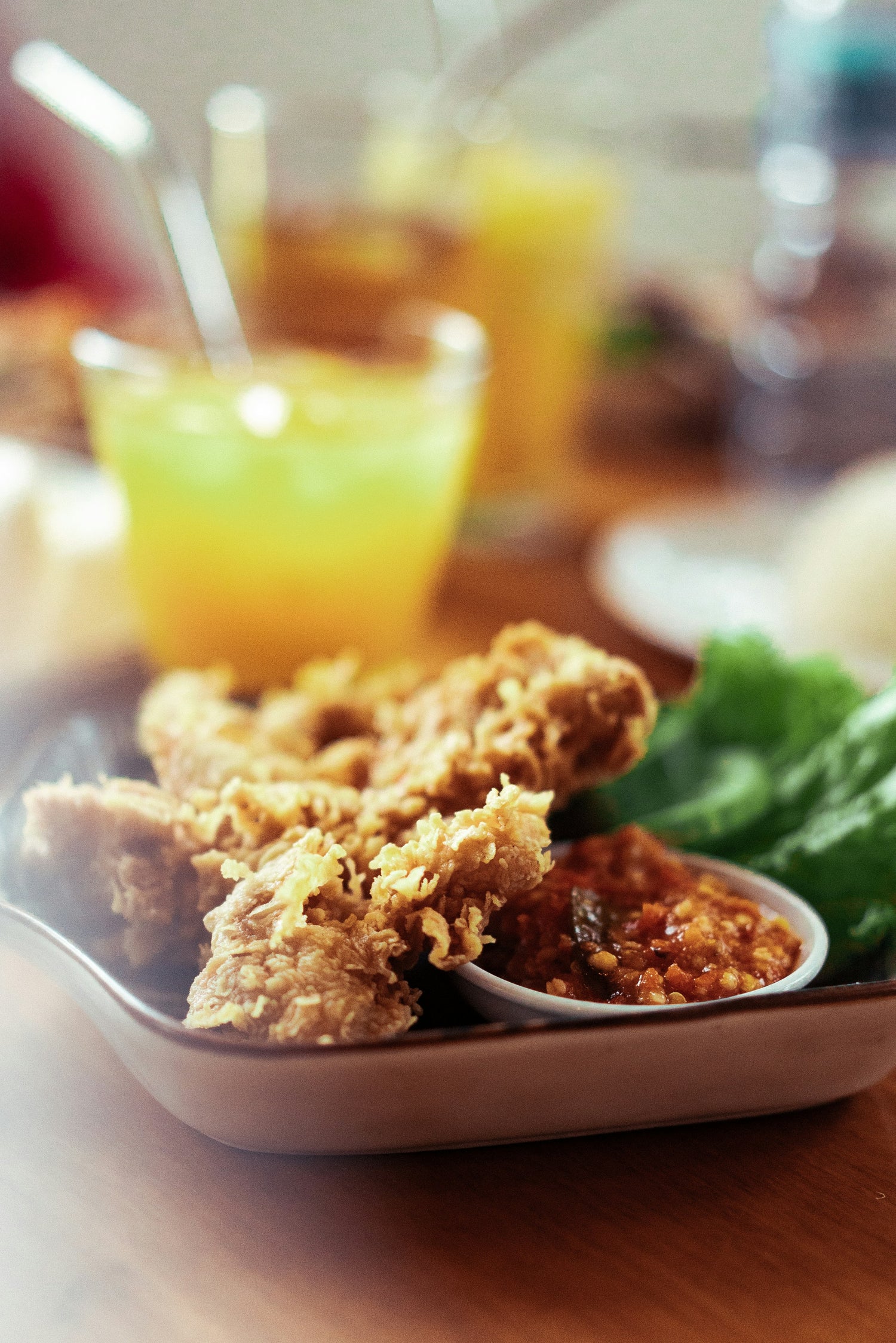 Hähnchenstücke knusprig frittiert, Sambal Oelek in separater Schale zum Dippen.