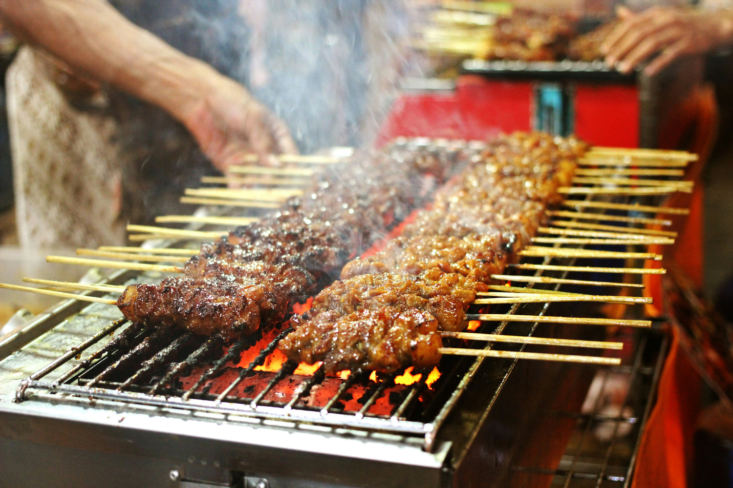 Satay-Spieße auf dem Grill über offener Flamme - saftig, leicht glasiert